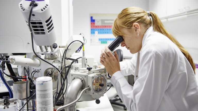 Wissenschaft Frau an einem Mikroskoparbeitsplatz