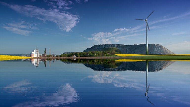 Salzbergwerk und Windkraftanlage vor blauem Himmel