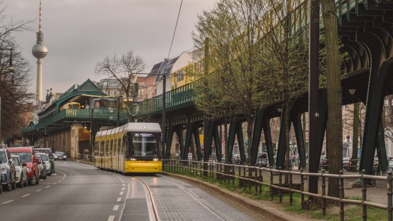 Eine Straßenbahn und eine U-Bahn in Berlin. Im Hintergrund der Fernsehturm.