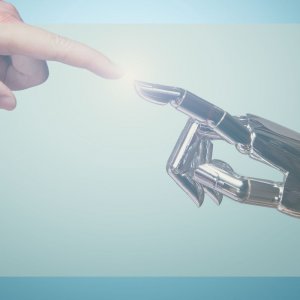 Menschen- und Roboterhand berühren sich gegenüber einander am Zeigefinger